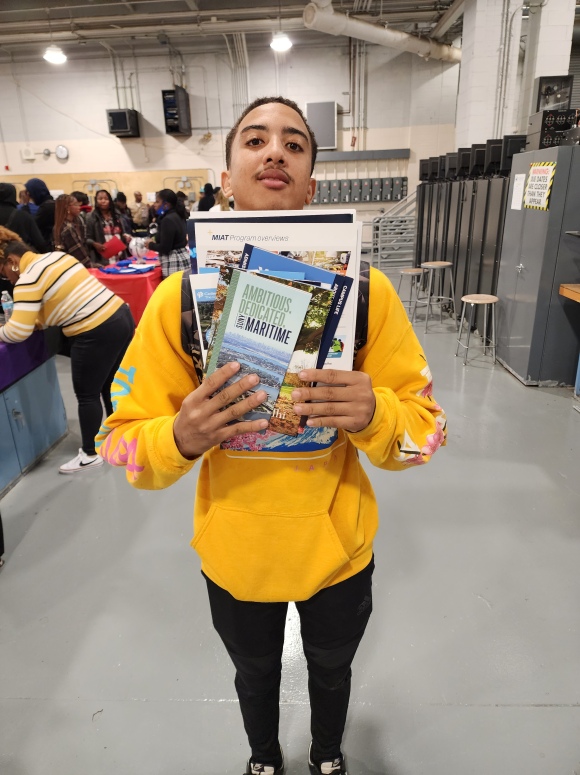 student holding college pamphlets

